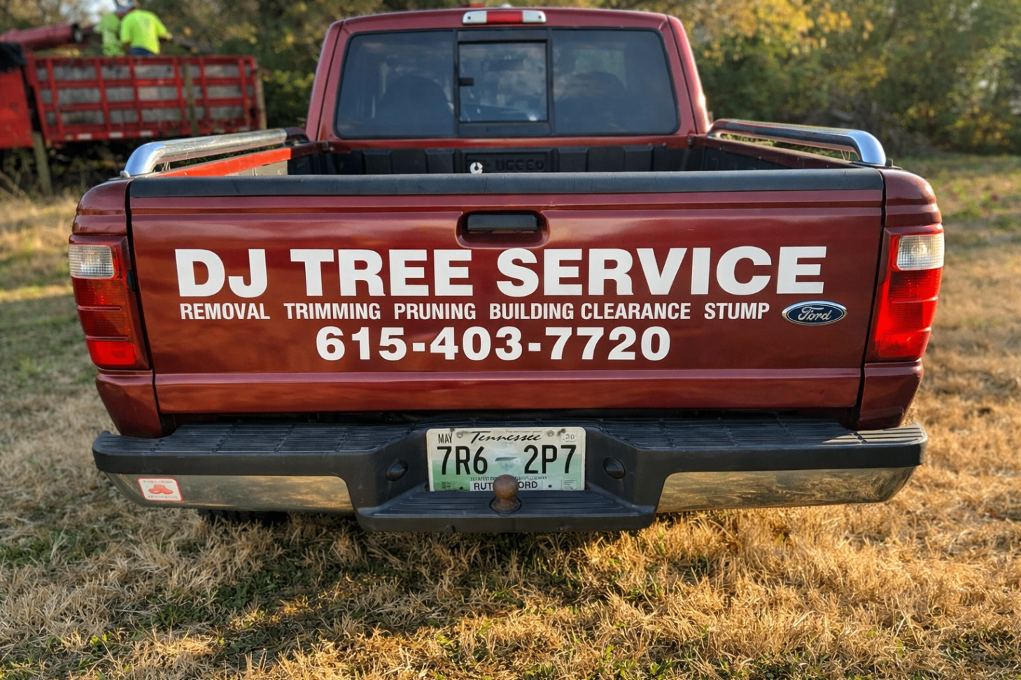 Rear tailgate branding on a red DJ Tree Service pickup truck