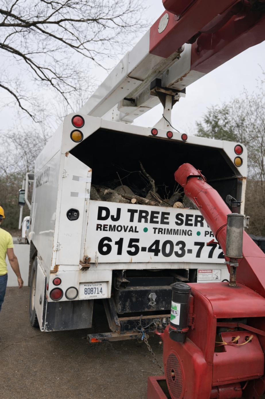 Rear view of a chip truck being loaded beside red machinery
