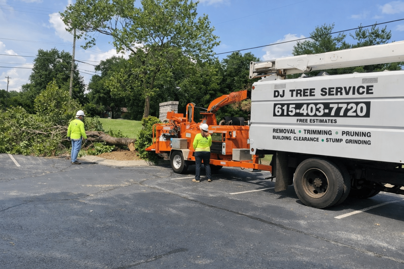 Crew working with a bucket truck and chipper during roadside cleanup